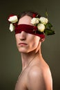 ART portrait of a handsome young man blindfolded and white roses. Male beauty. Royalty Free Stock Photo