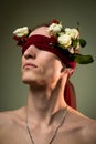ART portrait of a handsome young man blindfolded and white roses. Male beauty. Royalty Free Stock Photo