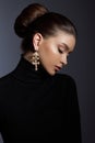 Art portrait woman in black turtleneck. Hair high beam, perfect profile face. Elegant beauty style. Earrings in the ears Royalty Free Stock Photo