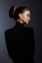 Art portrait woman in black turtleneck. Hair high beam, perfect profile face. Elegant beauty style. Earrings in the ears Royalty Free Stock Photo