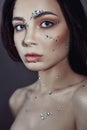 Art portrait of a woman with large crystals of rhinestones on her face, chest and body. Perfect makeup, skin care, professional Royalty Free Stock Photo