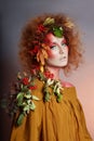 Art portrait of women autumn in her hair, vivid fall colors and makeup, red curly hair and voluminous hair. Leaves and berries