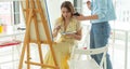 Art school, creativity and leisure concept - student girl or young woman artist with easel, palette and paint brush Royalty Free Stock Photo