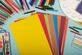 Art school supplies for painting and a set of colored paper on a blue background with copy space for text. Colorful pencils, Royalty Free Stock Photo