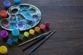 Art set, palette, paint, brushes on wooden background.