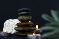 The art of stones with two burning candles and some flowers in black background used for relaxing concepts as yoga, massage and Royalty Free Stock Photo