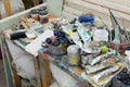 Art studio atelier table full of used artistic oil paint tube brush equipment workshop Royalty Free Stock Photo