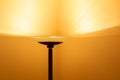 Art view of a modern pole lamp casting light upon a wall corner Royalty Free Stock Photo