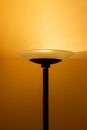 Art view of a modern pole lamp casting light upon a wall corner Royalty Free Stock Photo