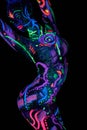 Art woman body art on the body dancing in ultraviolet light. Bright abstract drawings on the girl body neon color. Fashion and art