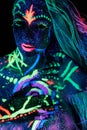 Art woman body art on the body dancing in ultraviolet light. Bright abstract drawings on the girl body neon color. Fashion and art