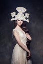 Art Woman with a long braid in a luxurious long dress and fabulous headpiece. Girl snow Queen posing on a dark background