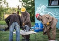 Art workers casting metal in a form