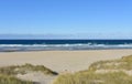 Summer landscape with Atlantic beach with waves breaking, grass in sand dunes and blue sky. Arteixo, CoruÃÂ±a, Galicia, Spain.