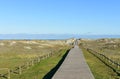 Beach with wooden boardwalk and sand dunes with grass and blue sky. Arteixo, CoruÃÂ±a, Galicia, Spain.