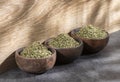 Artemisia dracunculus - Dried organic tarragon leaves in three wooden bowls