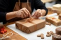 Artful packaging: Close-up showcases confectioner\'s hands expertly wrapping cardboard box with precision.