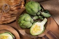 Artichoke close up. Fresh raw organic green Artichokes closeup. Over wooden table. Healthy vegetarian food.