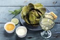 Artichoke cooked with dips on rustic blue wood