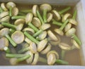 artichokes with stalks in water ready to be cooked for sale