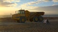 Articulated dump truck. Sea defense work on pebbled beach.