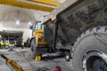 Articulated dump truck is serviced in an industrial garage.