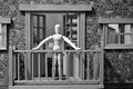 Articulated wooden doll on the balcony of a rural house