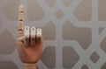 Articulated wooden hand with a finger raised in allusion to number one Royalty Free Stock Photo