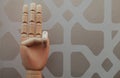 Articulated wooden hand with three fingers raised in allusion to number three Royalty Free Stock Photo