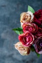 Artificial antique roses on stony background. Royalty Free Stock Photo