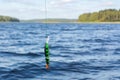 Artificial bait for predatory fish on a fishing line above the water