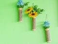 Artificial blue and yellow flower in bamboo pot hang on green wall. Copy space for your text Royalty Free Stock Photo