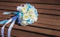 Artificial bouquet of white roses is on the bench