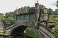 An artificial bridge with four statues of dragons with twisted tails, Tirta Gangga park, Karangasem region of Bali Royalty Free Stock Photo