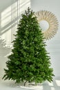 Artificial Christmas green tree without decorations on a metal stand isolated on a white background. Royalty Free Stock Photo