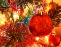 Artificial christmas tree with toys, garlands and lights. Shiny christmas red ball hanging on pine branches Royalty Free Stock Photo