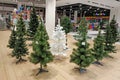 Artificial Christmas trees of different colors and sizes for sale in a supermarket.