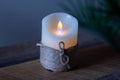 Artificial decorative candle wrapped with a thick thread.