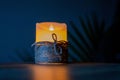 Artificial decorative candle wrapped with a thick thread isolated on a dark background.