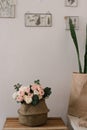 artificial decorative flowers in a vase on a white wall background
