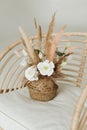 artificial decorative flowers in a wicker basket on an armchair