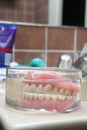 Artificial denture in a glass