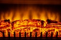 Artificial electric fireplace with orange, red and yellow flames. Royalty Free Stock Photo