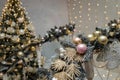 Artificial fir tree branches with baubles and shiny golden decorative elements on blurry decorated Christmas tree background Royalty Free Stock Photo