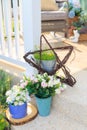 An artificial flowers in blue pot on floor in a porch. Royalty Free Stock Photo