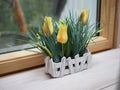 Artificial flowers in crafting pots on a wooden windowsill, ecodesign