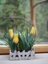 Artificial flowers in crafting pots on a wooden windowsill, ecodesign