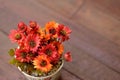 Artificial flowers in small pot on wooden table with empty space Royalty Free Stock Photo