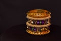 Artificial golden and colored bangles close up on a black background