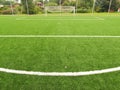 Artificial grass field on football playground. Detail of a cross of lines in a soccer field. Plastic grass and ground rubber